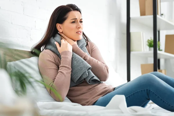 Schöne kranke Frau in Schal mit Halsschmerzen zu Hause — Stockfoto