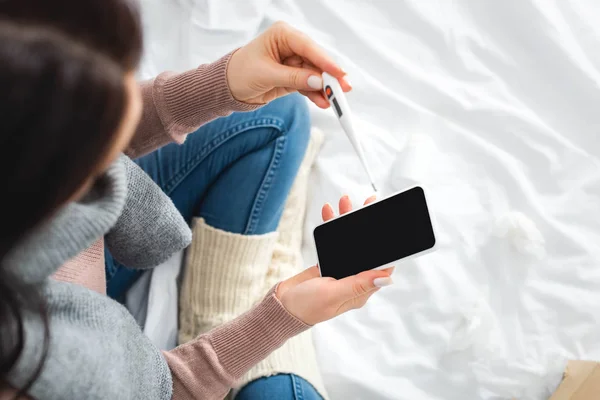 Vista ritagliata di donna malata con febbre avendo consultazione online con il medico su smartphone — Foto stock