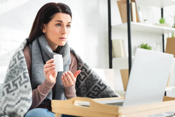 Kranke Frau mit Tabletten und Online-Arztkonsultation am Laptop — Stockfoto