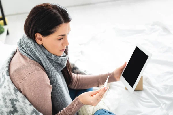 Femme malade avec fièvre ayant une consultation en ligne avec un médecin sur tablette numérique — Photo de stock