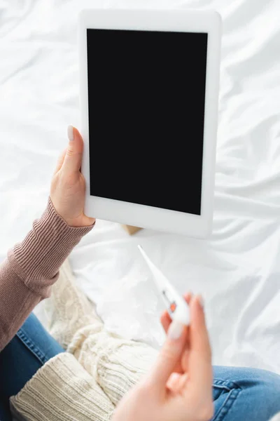 Vista recortada de la mujer enferma con fiebre que tiene consulta en línea con el médico en tabletas digitales - foto de stock