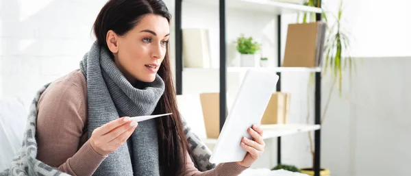 Panoramic shot of sick woman with fever having online consultation with doctor on digital tablet — Stock Photo