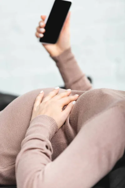 Обрезанный взгляд беременной женщины, имеющей онлайн консультации с врачом на смартфоне — стоковое фото