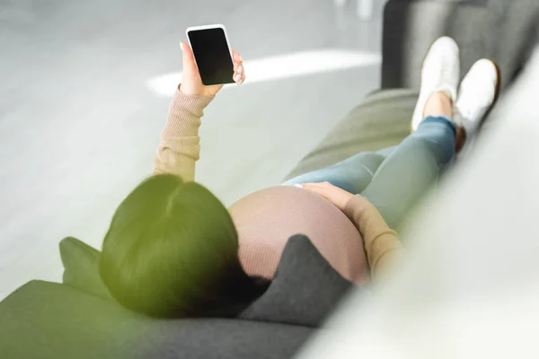 Обрізаний вид вагітної пацієнтки, що має онлайн-консультацію з лікарем на смартфон — стокове фото