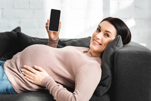 Счастливая беременная с онлайн-консультацией врача на смартфоне с Blank-экраном — стоковое фото
