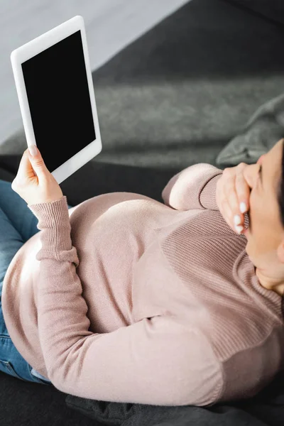 Усталая беременная женщина зевает и имеет онлайн консультации с врачом на цифровых таблетках — стоковое фото