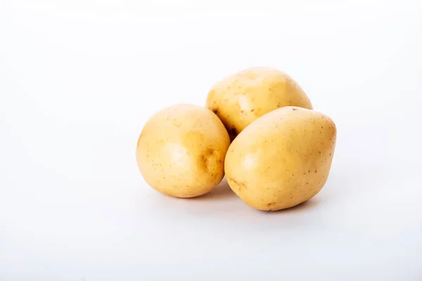 Patatas crudas ecológicas sobre fondo blanco - foto de stock