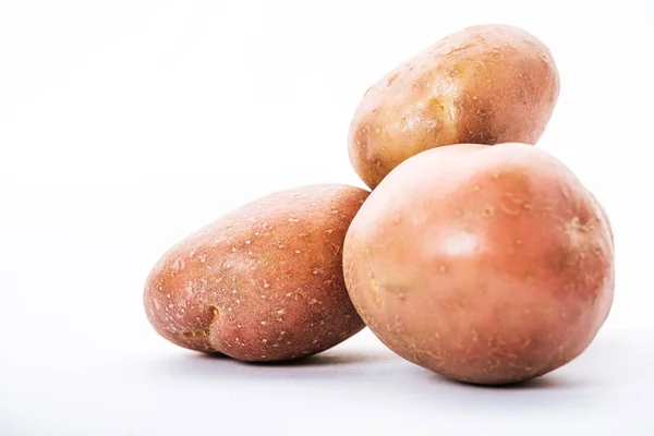 Patatas crudas ecológicas sobre fondo blanco - foto de stock