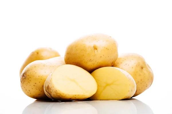 Patatas frescas crudas enteras y cortadas aisladas en blanco - foto de stock