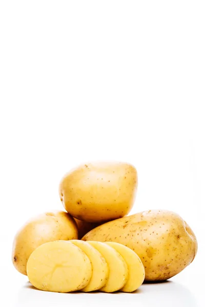 Patate fresche crude intere e tagliate a fette isolate su bianco — Foto stock