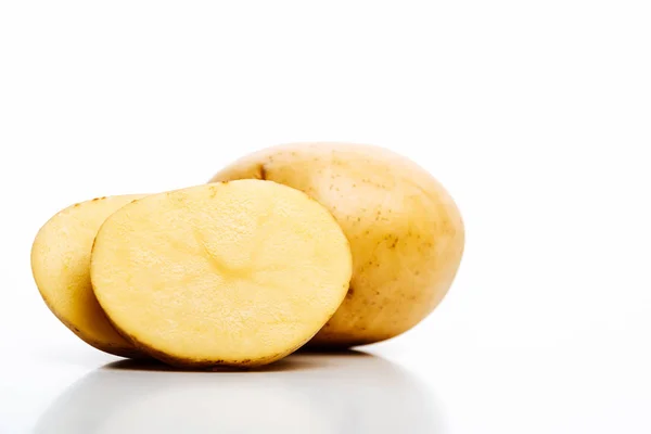 Patatas frescas crudas enteras y cortadas aisladas en blanco - foto de stock