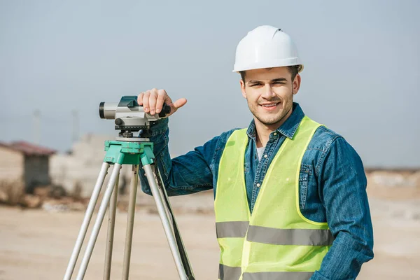 Inspetor sorridente com nível digital olhando para a câmera — Fotografia de Stock