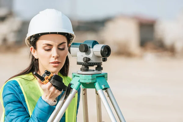 Surveyor with digital level talking on radio set — Stock Photo