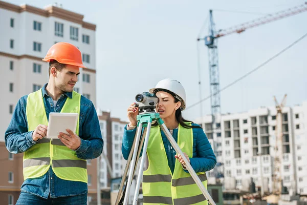 Inspetores que trabalham com tablet digital e nível de medição no canteiro de obras — Fotografia de Stock