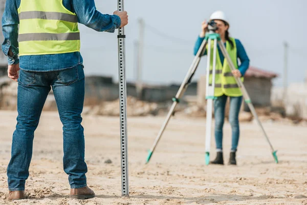 Selektive Fokussierung der Vermessungsingenieure mit Lineal und digitaler Ebene — Stockfoto