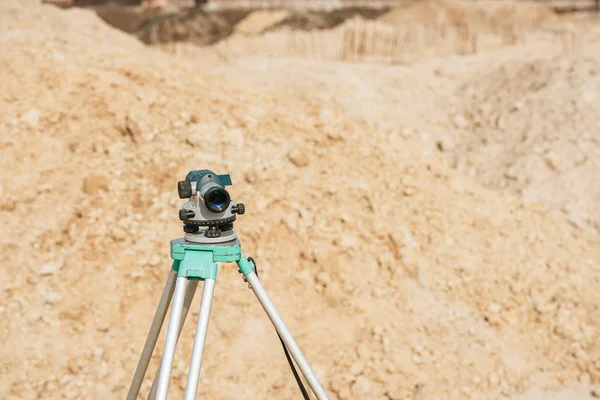 Nivel digital en trípode con montículos de arena sobre fondo - foto de stock