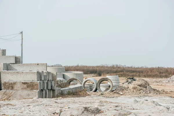 Concrete blocks and building materials in field — Stock Photo