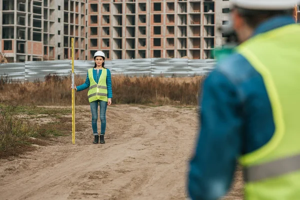 Selective focus of surveyors measuring land on construction site — Stock Photo