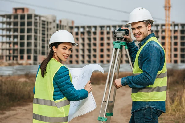 Smiling Surveyors avec plan et niveau numérique — Photo de stock