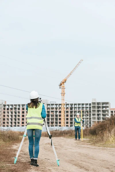 Vermessungsingenieure messen Grundstücke auf Feldweg der Baustelle — Stockfoto