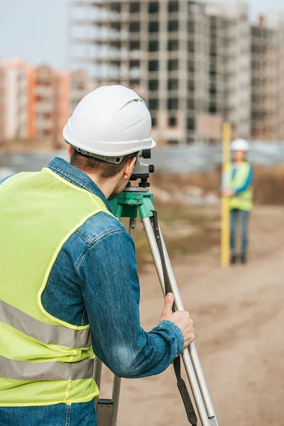 Foco seletivo dos agrimensores que medem terreno com nível digital no canteiro de obras — Fotografia de Stock