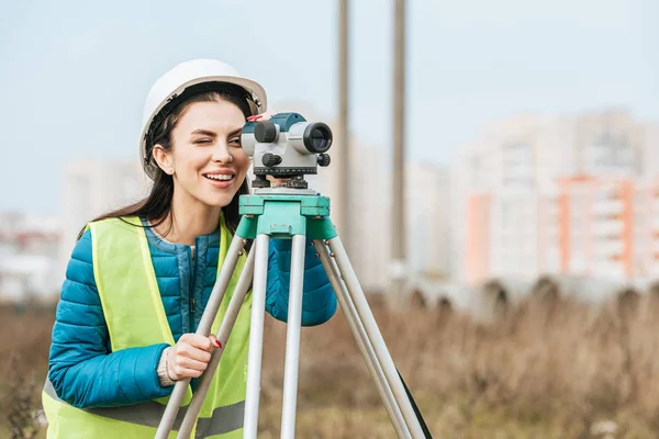 Surveyor sorridente guardando attraverso il livello digitale — Foto stock