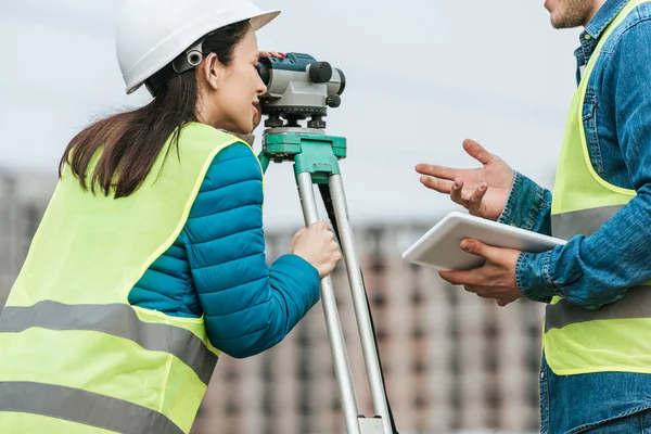 Cropped view of surveyors working with digital level and tablet — Stock Photo