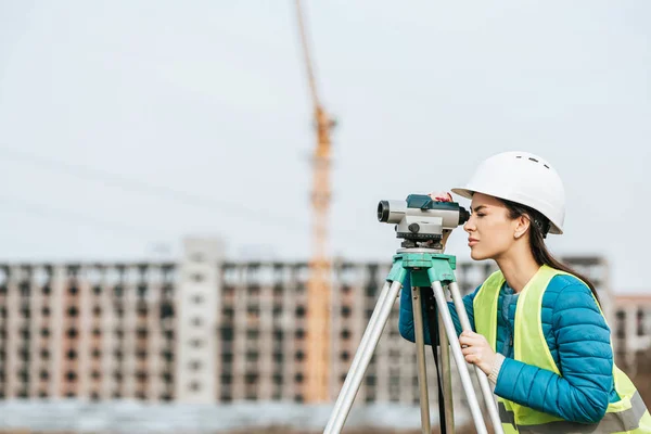 Seitenansicht des Vermessungsingenieurs, der mit digitaler Ebene arbeitet — Stockfoto