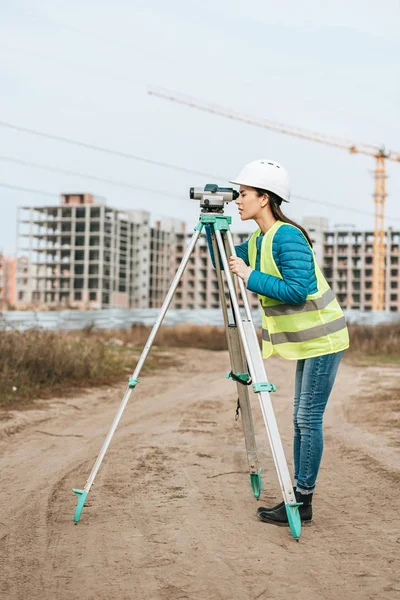 Surveyor trabalhando com nível digital em estrada de terra — Fotografia de Stock