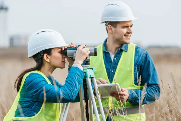 Vermessungsingenieure arbeiten mit digitalem Pegel und Tablet im Feld — Stockfoto