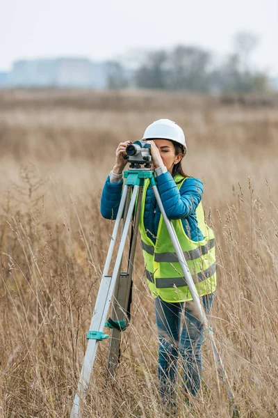 Женщина-геодезист, работающая с цифровым уровнем в поле — стоковое фото