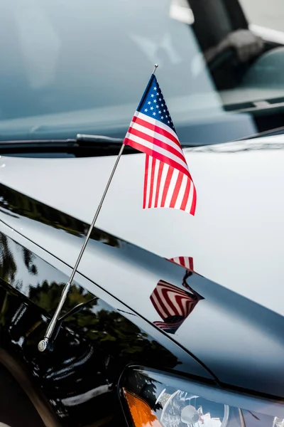 Bandeira americana com estrelas e listras em carro preto — Fotografia de Stock