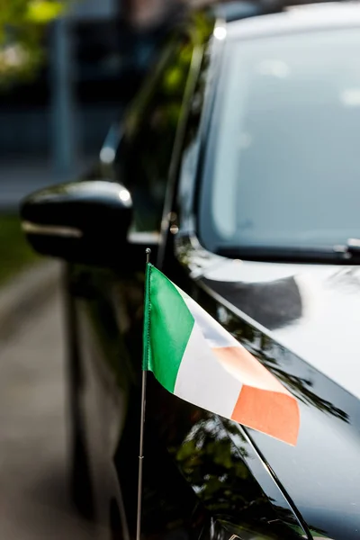 Foco seletivo da bandeira irlandesa no carro preto moderno — Fotografia de Stock