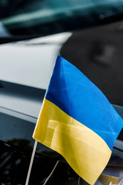 Close up on ukrainian flag near black modern car — Stock Photo