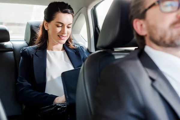 Selective focus of attractive ambassador sitting in car with diplomat — Stock Photo