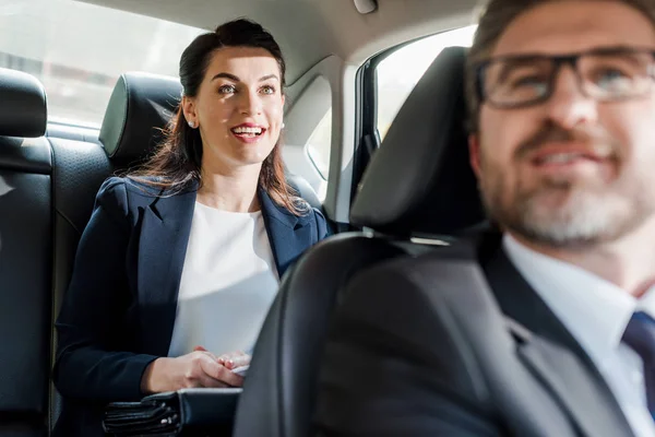 Foyer sélectif de femme heureuse assise dans la voiture près ambassadeur barbu — Photo de stock