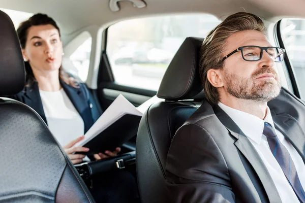 Enfoque selectivo de diplomático barbudo sentado en coche con la mujer — Stock Photo