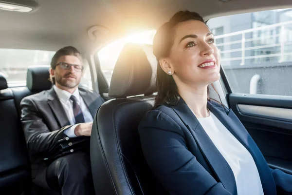 Enfoque selectivo de mujer atractiva sentada en coche con diplomático barbudo - foto de stock