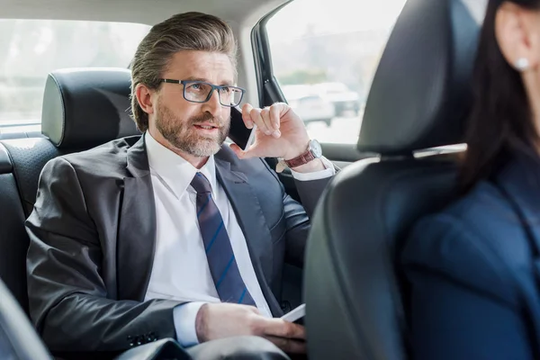 Selektiver Fokus eines gut aussehenden Diplomaten, der Ordner im Auto hält — Stockfoto