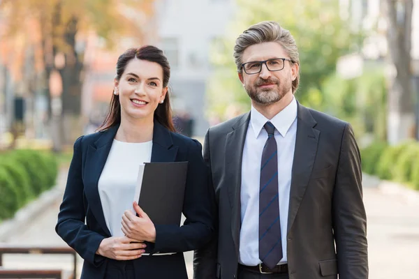 Heureux homme et femme en tenue formelle regardant la caméra — Photo de stock