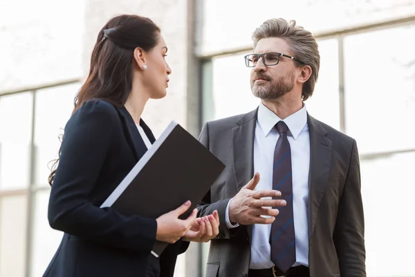 Attractive ambassador talking with handsome diplomat in glasses outside — Stock Photo