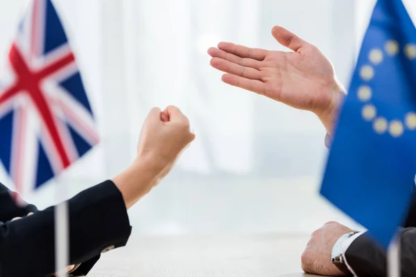 Cropped view of diplomat of european union near ambassador of united kingdom showing clenched fist — Stock Photo