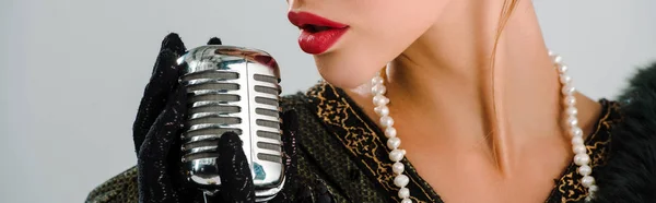 Panoramic shot of woman touching retro microphone isolated on grey — Stock Photo