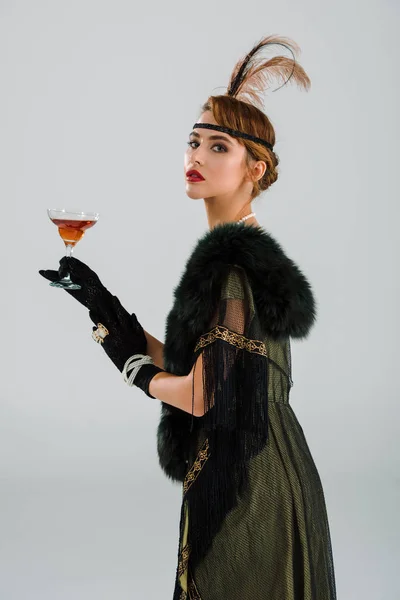 Aristocratic woman holding alcohol drink isolated on grey — Stock Photo