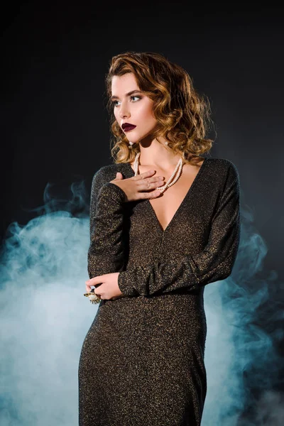 Attraente donna toccante collana di perle su nero con il fumo — Foto stock