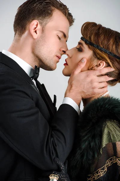 Vista lateral de hombre y mujer con estilo besos aislados en blanco - foto de stock