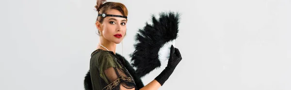 Plano panorámico de mujer aristocrática sosteniendo abanico de plumas negro aislado en gris - foto de stock