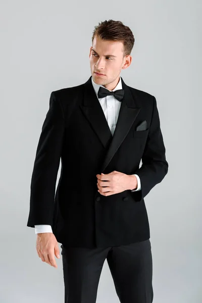 Schöner reicher Mann im Anzug steht isoliert auf grau — Stockfoto