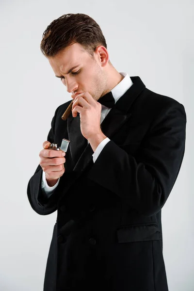 Homem bonito e rico fumando charuto e segurando isqueiro isolado no branco — Fotografia de Stock