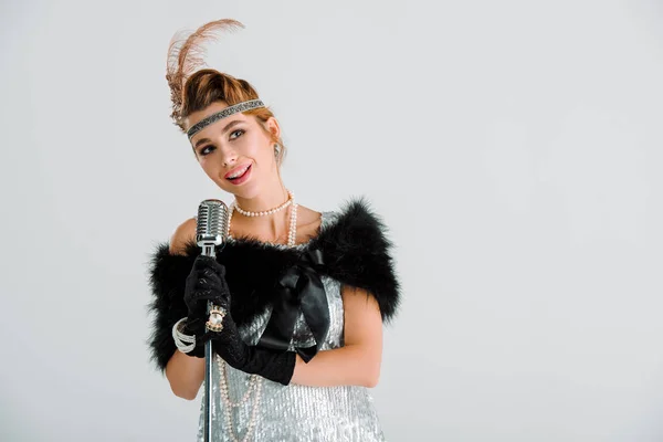 Heureuse jeune femme près de microphone rétro isolé sur blanc — Photo de stock